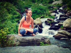 Indian woman doing ashtanga vinyasa yoga arm balance