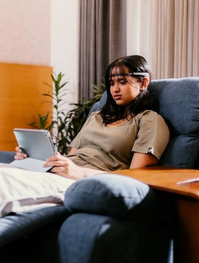 Young woman reading about the addiction recovery process of rehab online.