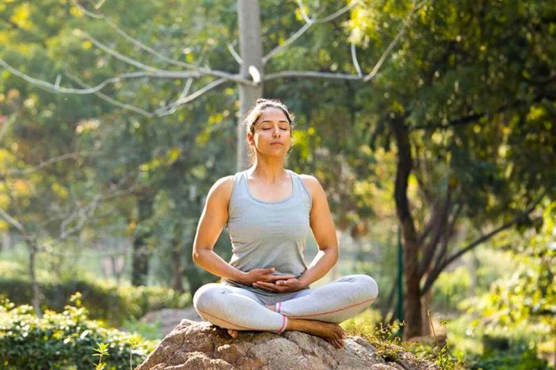 Young woman meditating and feeling calm by her surroundings.