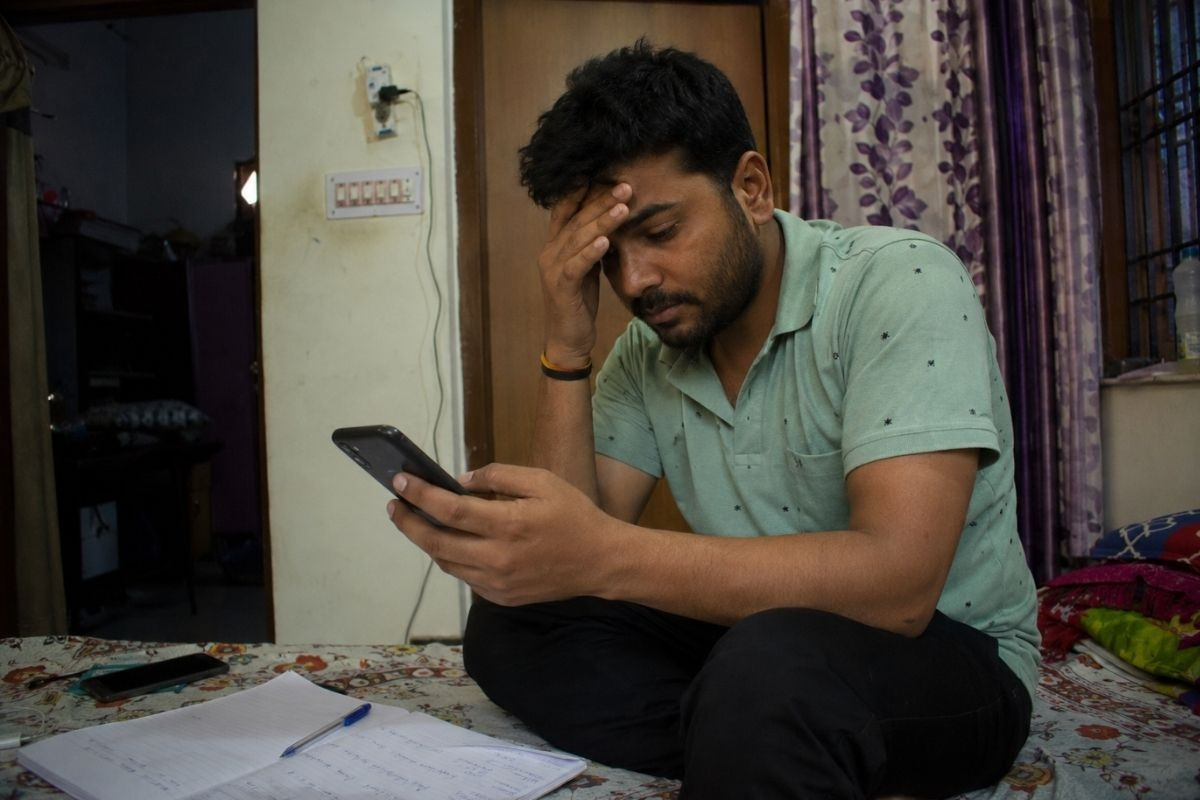 Young man searching for a Reliable Nasha Mukti Kendra Near Me with Patient Reviews on his smartphone.