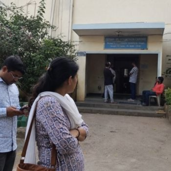 An elderly woman is evaluating a trustworthy rehab center in India before paying for treatment.